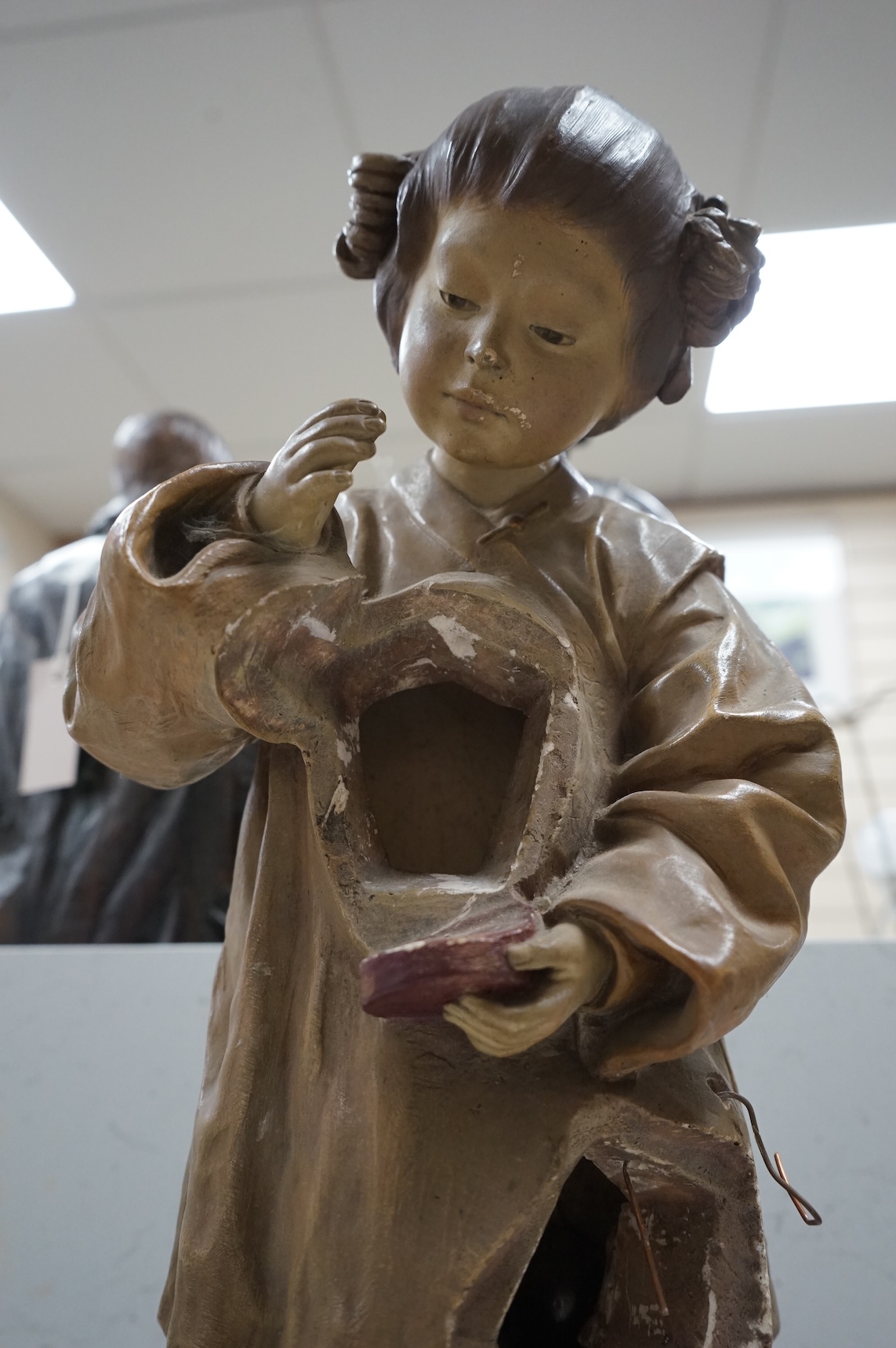 A Goldscheider cold-painted terracotta figural lamp with two cranberry glass shades, 55cm high